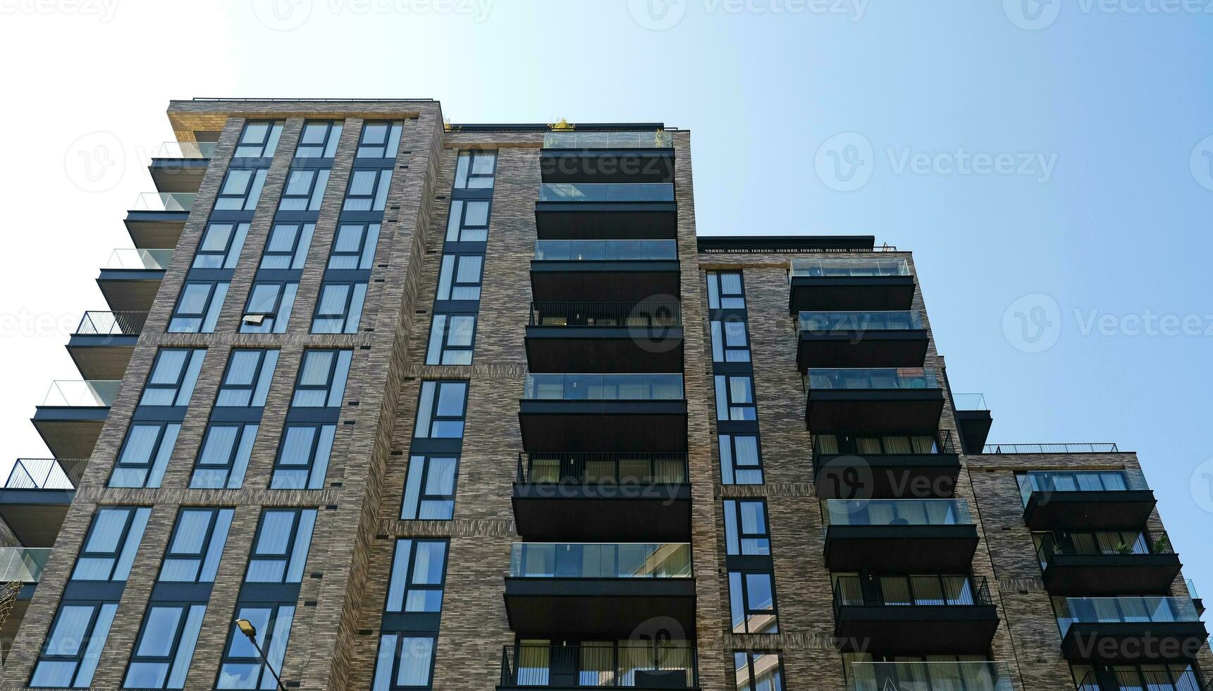 Exterior of modern brick house object. Architectural detail of a skyscraper, close-up on the windows. Real estate, residential apartments and offices. Living apartments or office building architecture photo