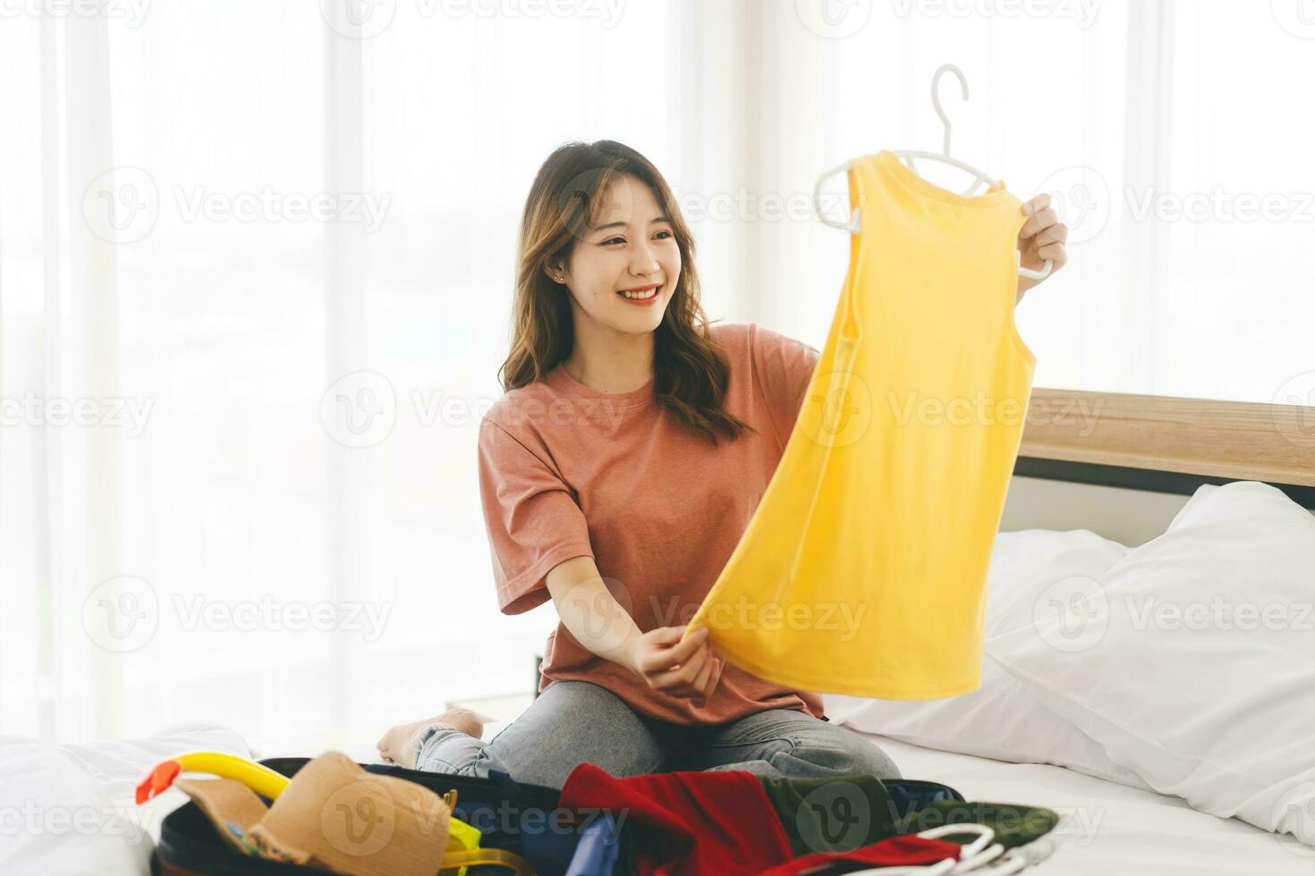 Portrait of young adult southeast asian woman packing travel luggage photo