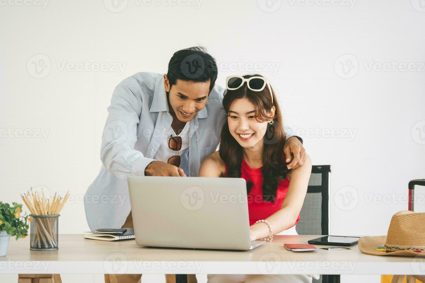 Focus on woman young adult southeast asian couple using laptop getting ready for honeymoon travel trip photo