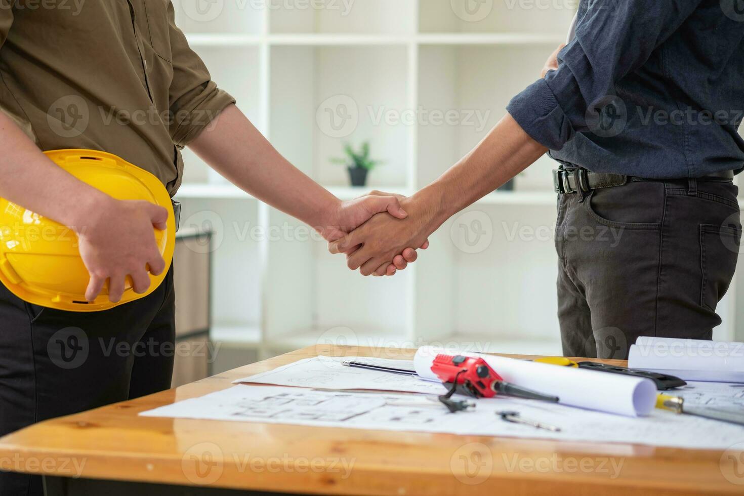 Asian engineers stand hand in hand to work together to document cost estimates and write floor plans for architectural and engineering designs for houses and buildings. photo