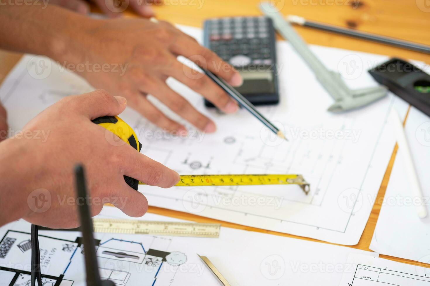 Asian engineers brainstorm and measure to document cost estimates and write floor plans for architectural and engineering designs for houses and buildings. photo
