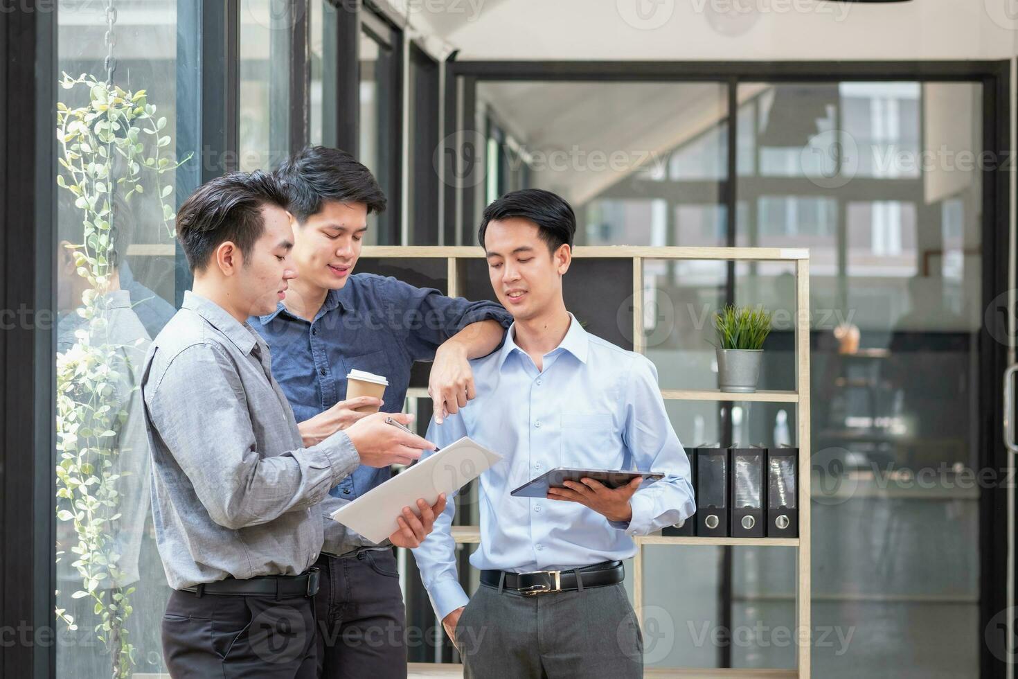 Asian business team consists of marketing staff. accountant and financial officer Help each other analyze company profits using tablets. calculator Laptop computers, graph paper, and corporate pens. photo