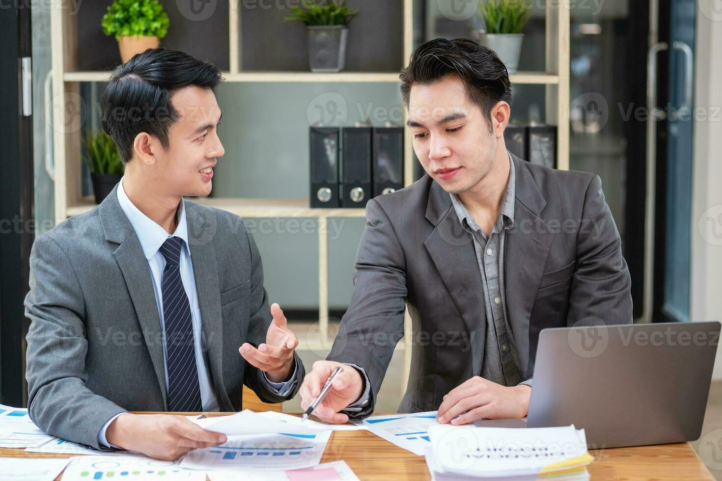 Asian business team consists of marketing staff. accountant and financial officer Help each other analyze company profits using tablets. calculator Laptop computers, graph paper, and corporate pens. photo