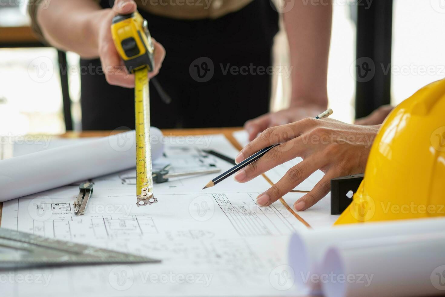 Asian engineers brainstorm and measure to document cost estimates and write floor plans for architectural and engineering designs for houses and buildings. photo