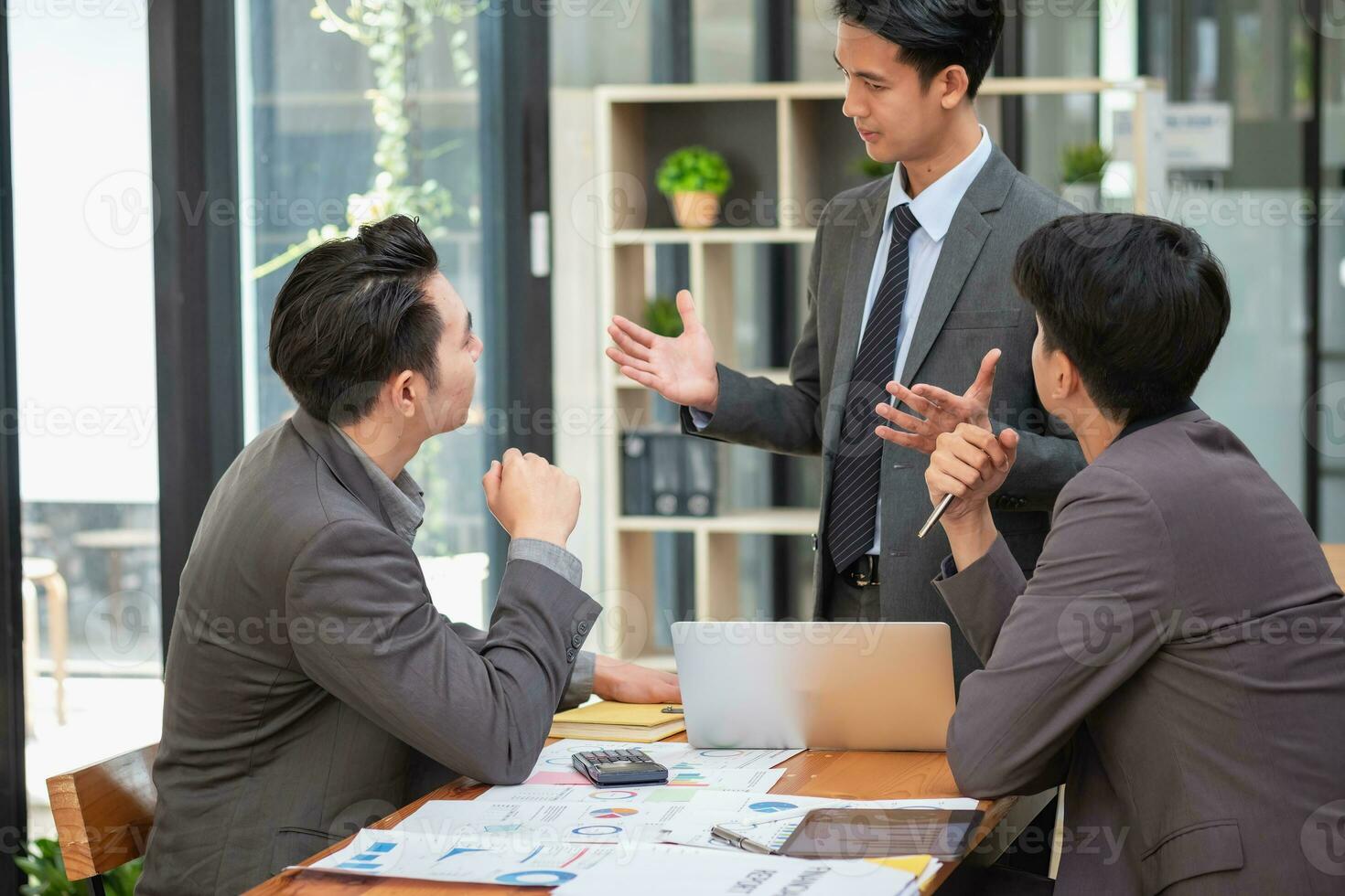 Asian business team consists of marketing staff. accountant and financial officer Help each other analyze company profits using tablets. calculator Laptop computers, graph paper, and corporate pens. photo