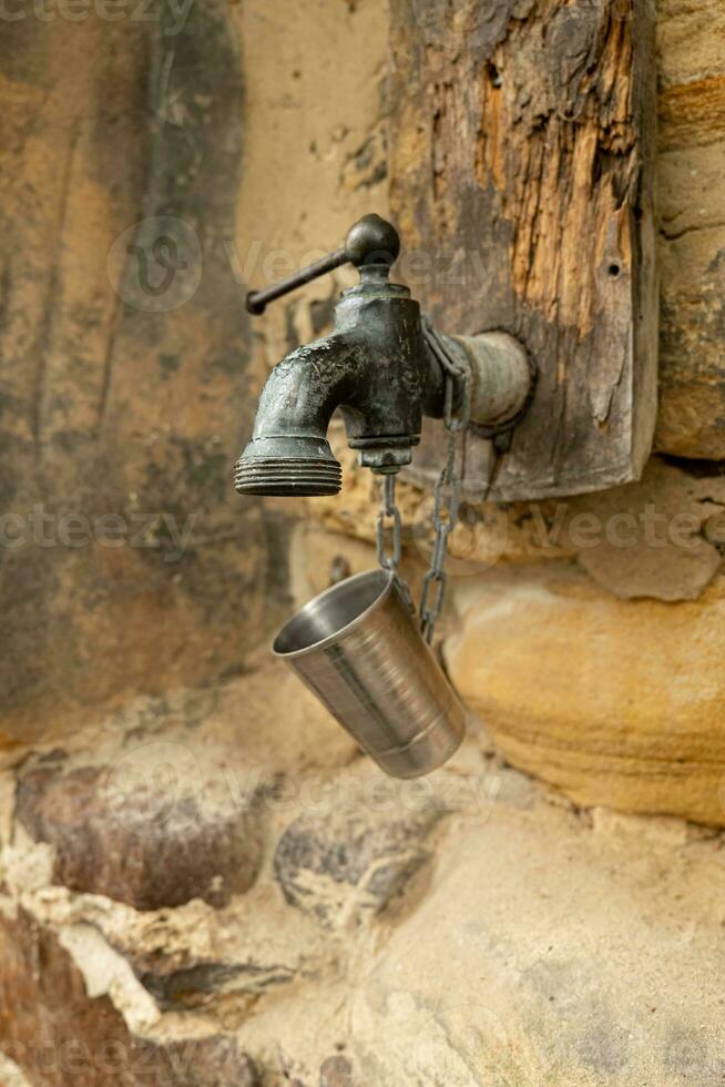 an old faucet on a stone wall photo