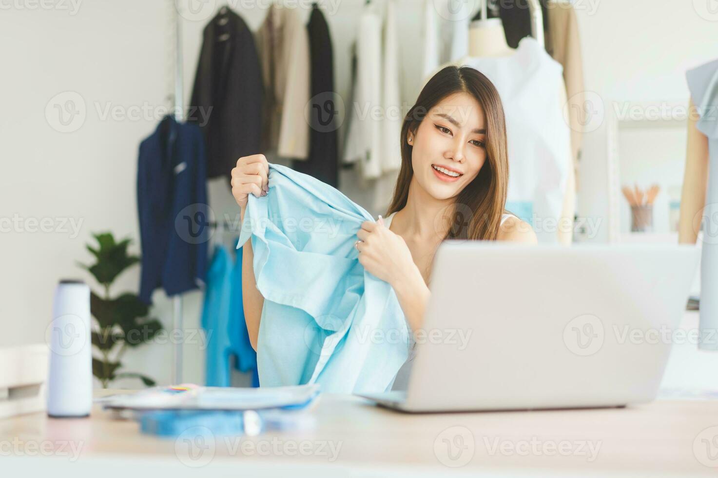 Young adult asian woman tailor designer using laptop computer for internet online marketing contact customer photo
