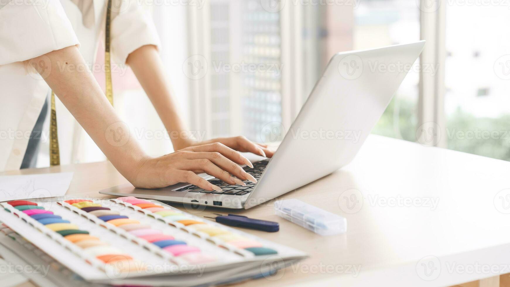 Closeup hand of working designer tailor woman typing lapto computer for digital online marketing photo