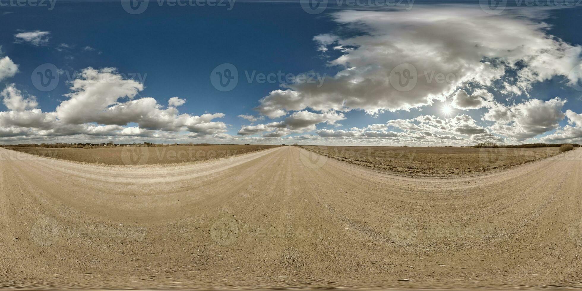 spherical 360 hdri panorama on gravel road with clouds and sun on blue sky in equirectangular seamless projection, use as sky replacement in drone panoramas, game development as sky dome or VR content photo