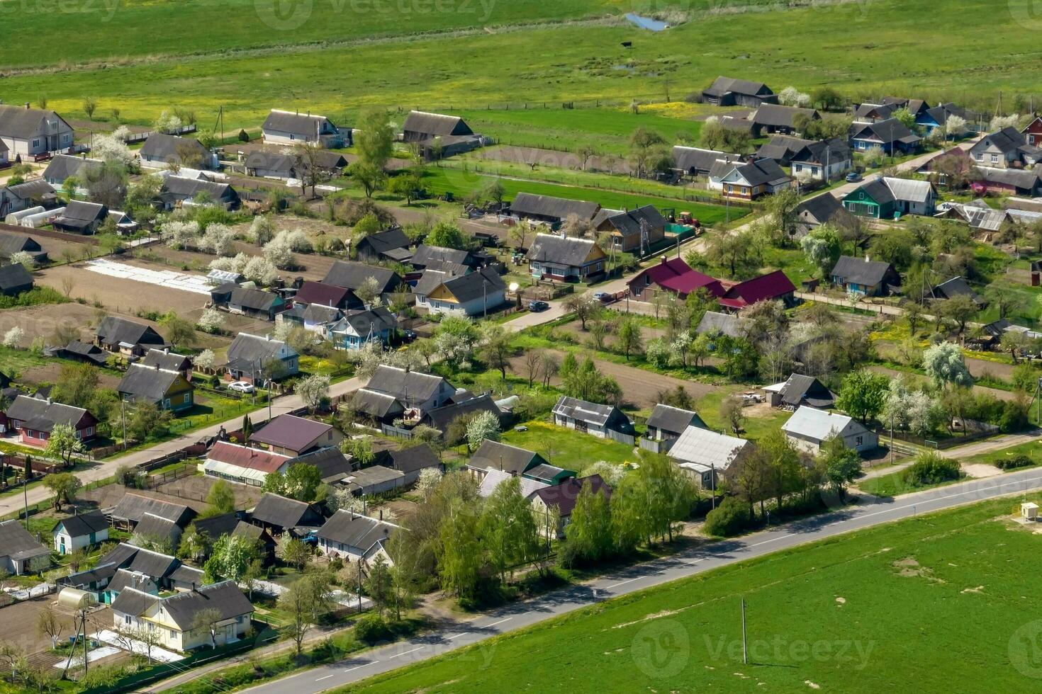 panoramic aerial view of eco village with wooden houses, gravel road, gardens and orchards photo