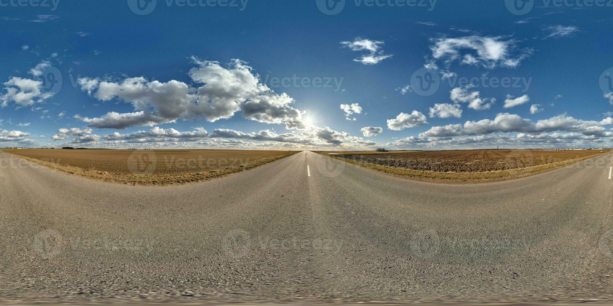 spherical 360 hdri panorama on asphalt road with clouds and sun on blue sky in equirectangular seamless projection, as sky replacement in drone panoramas, game development as sky dome or VR content photo