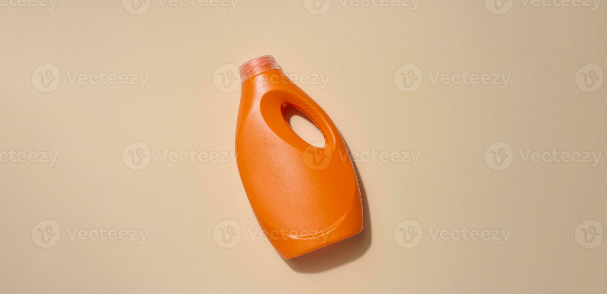 naranja el plastico botella para líquido detergentes, para Lavado ropa en un beige fondo, parte superior ver foto