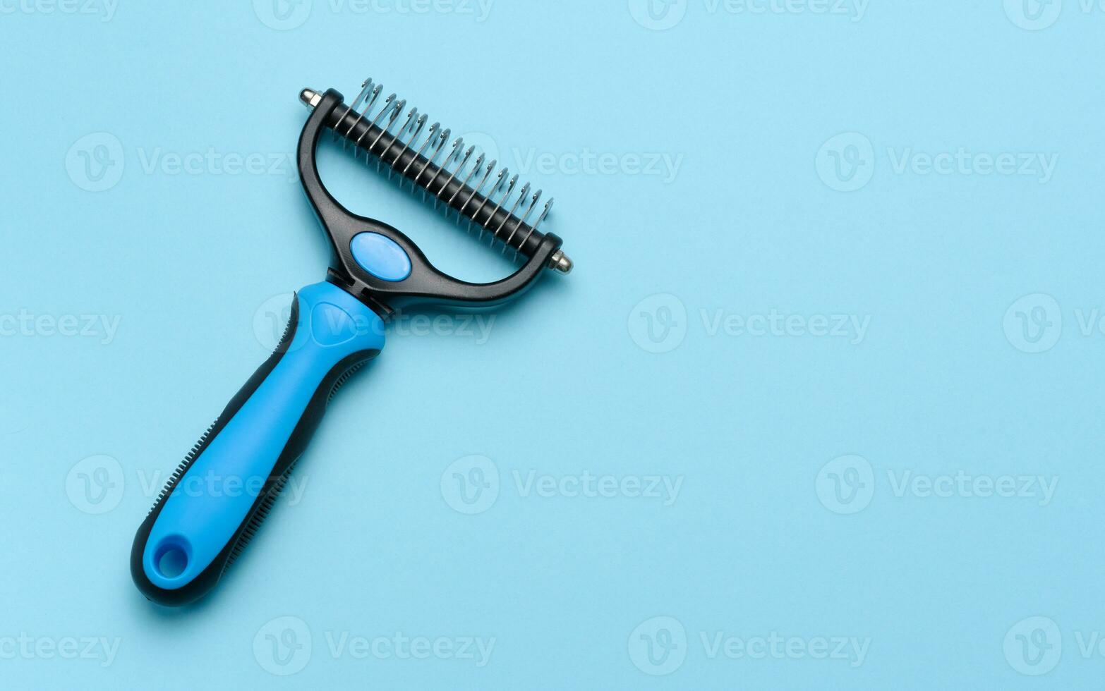 Brush for grooming cats and dogs on a blue background, top view photo