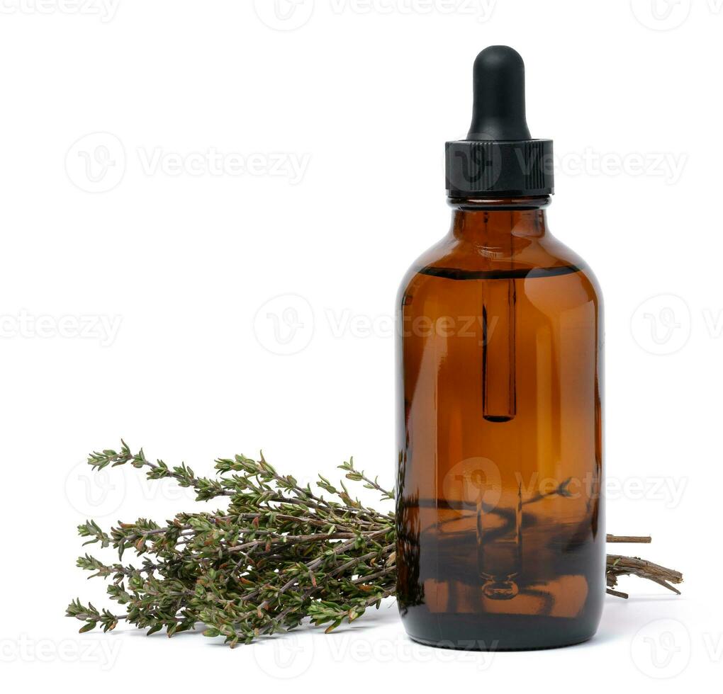 A glass brown bottle with a pipette and a branch of cumin on a white isolated background, a container for oils and essences photo