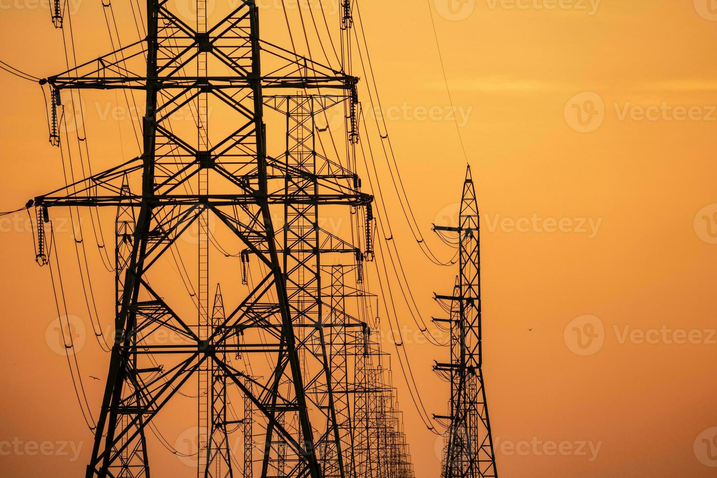 High voltage electric transmission tower. High voltage power lines on electric pylon against a sunset sky. Electrical infrastructure. Energy crisis. Electric power distribution. Energy distribution. photo