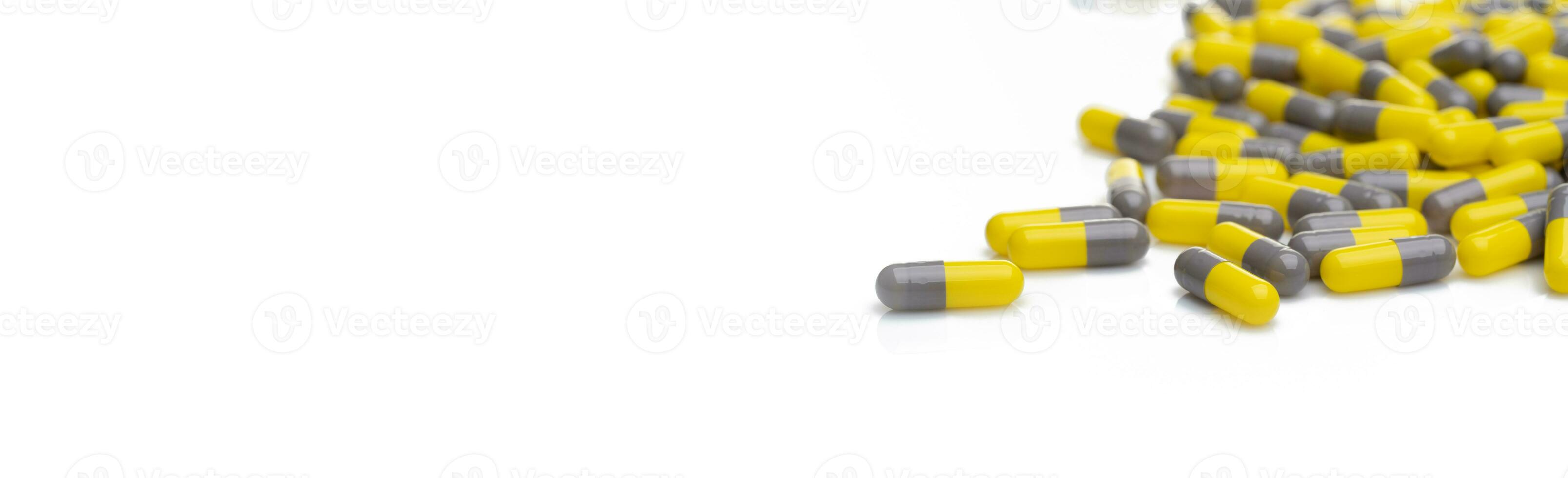 Yellow and gray probiotic capsule pill on white background. Probiotic supplement. Gut health. Dietary supplements. Probiotics for a healthy gut. Lactobacillus acidophilus and Bifidobacterium animalis. photo