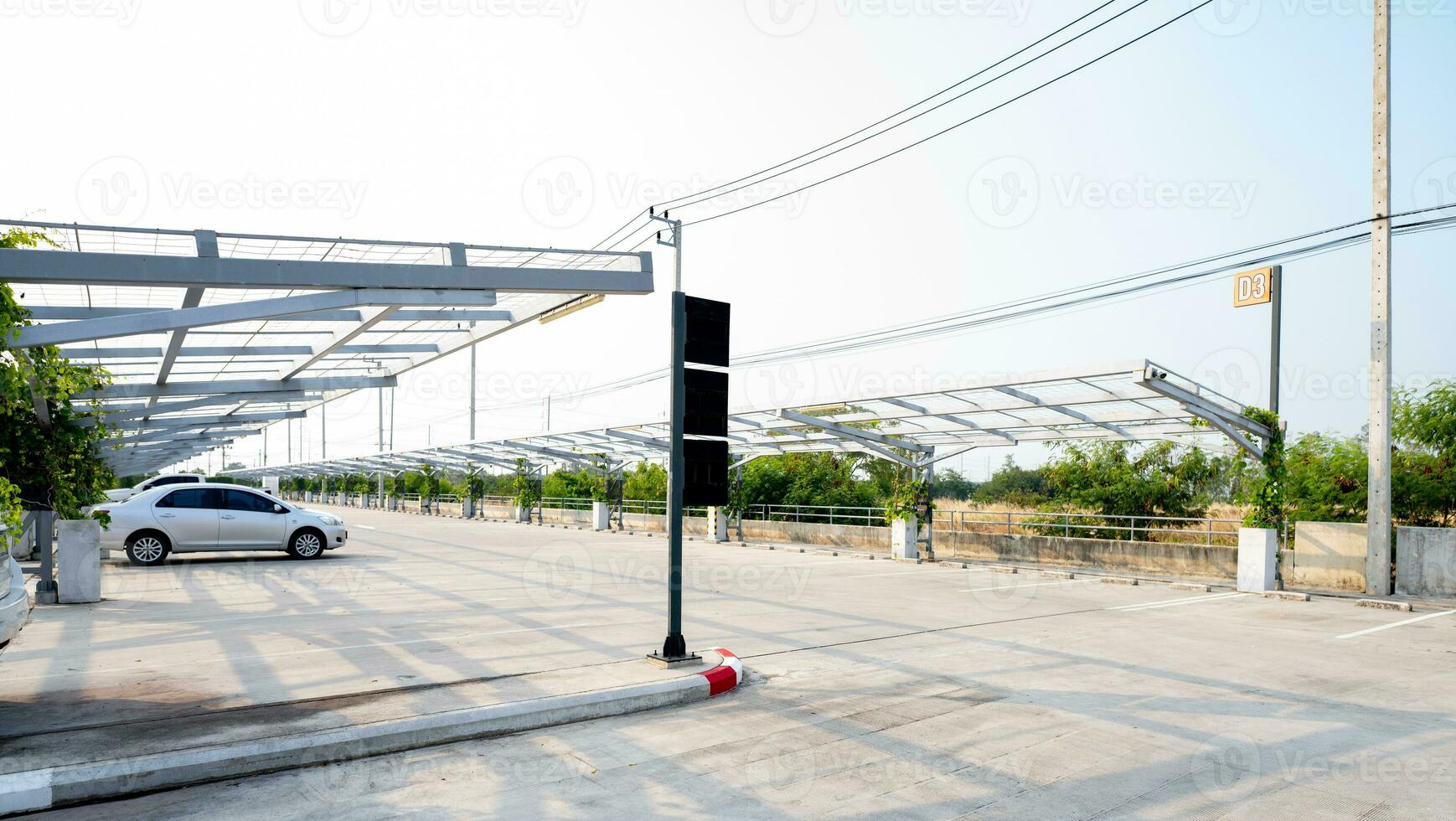 Concrete car parking lot with empty space. Private car park for customer service. Parking zone on a sunny day. Outdoor parking lot of shopping mall. Outdoor car parking lot with green climbing plant. photo