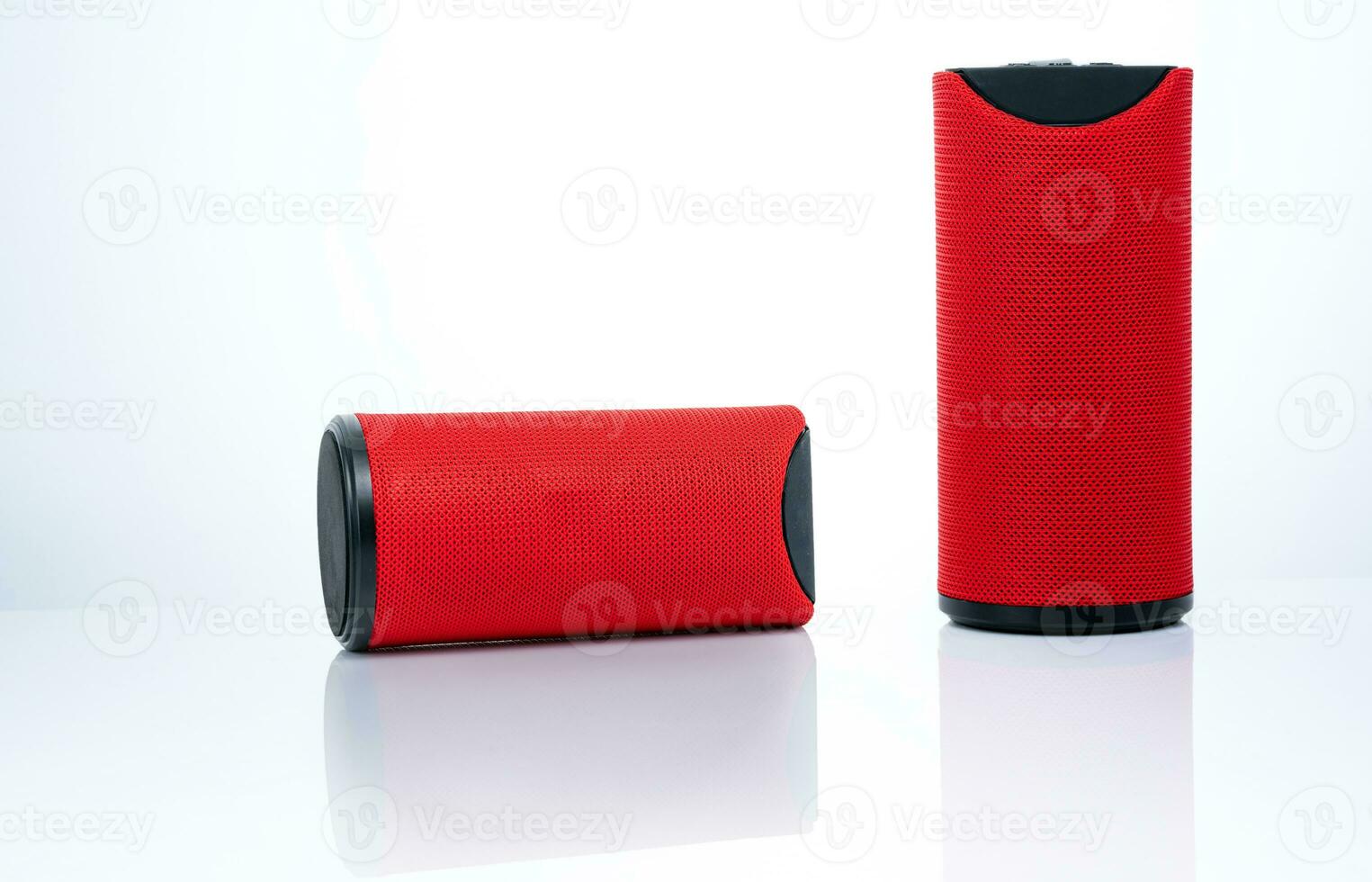 Wireless portable speaker isolated on white background. Red Digital portable speakers. Small sound music box speaker. Modern design mini portable Wireless loudspeaker. Digital wireless technology. photo