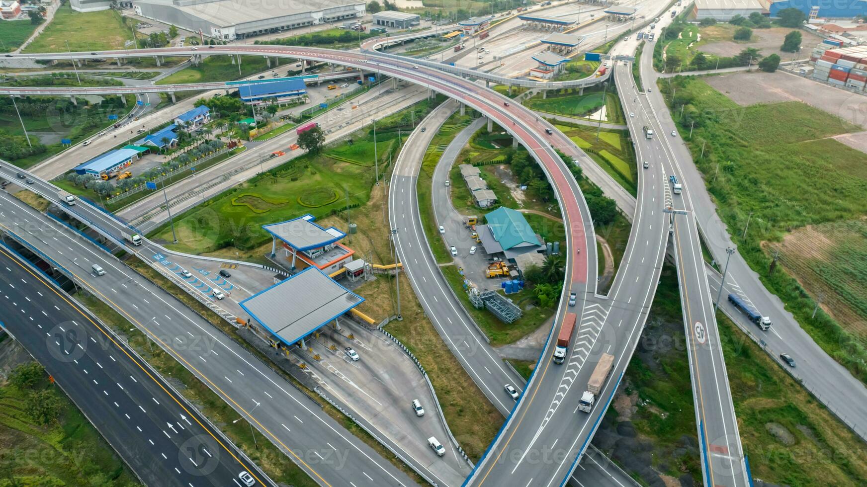 Aerial top view of highway junction interchange road. Drone view of the elevated road, traffic junctions, and green garden. Transport trucks and cars driving on highway. Infrastructure in modern city. photo