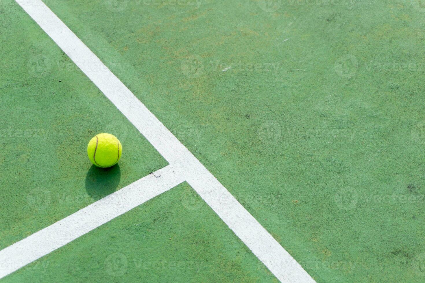 amarillo tenis pelota en verde Corte y blanco líneas. parte superior ángulo ver de tenis pelota en corte. foto