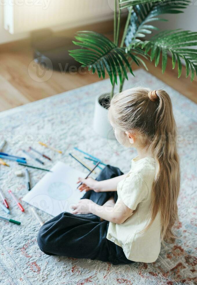 Child girl drawing with colorful pencils photo