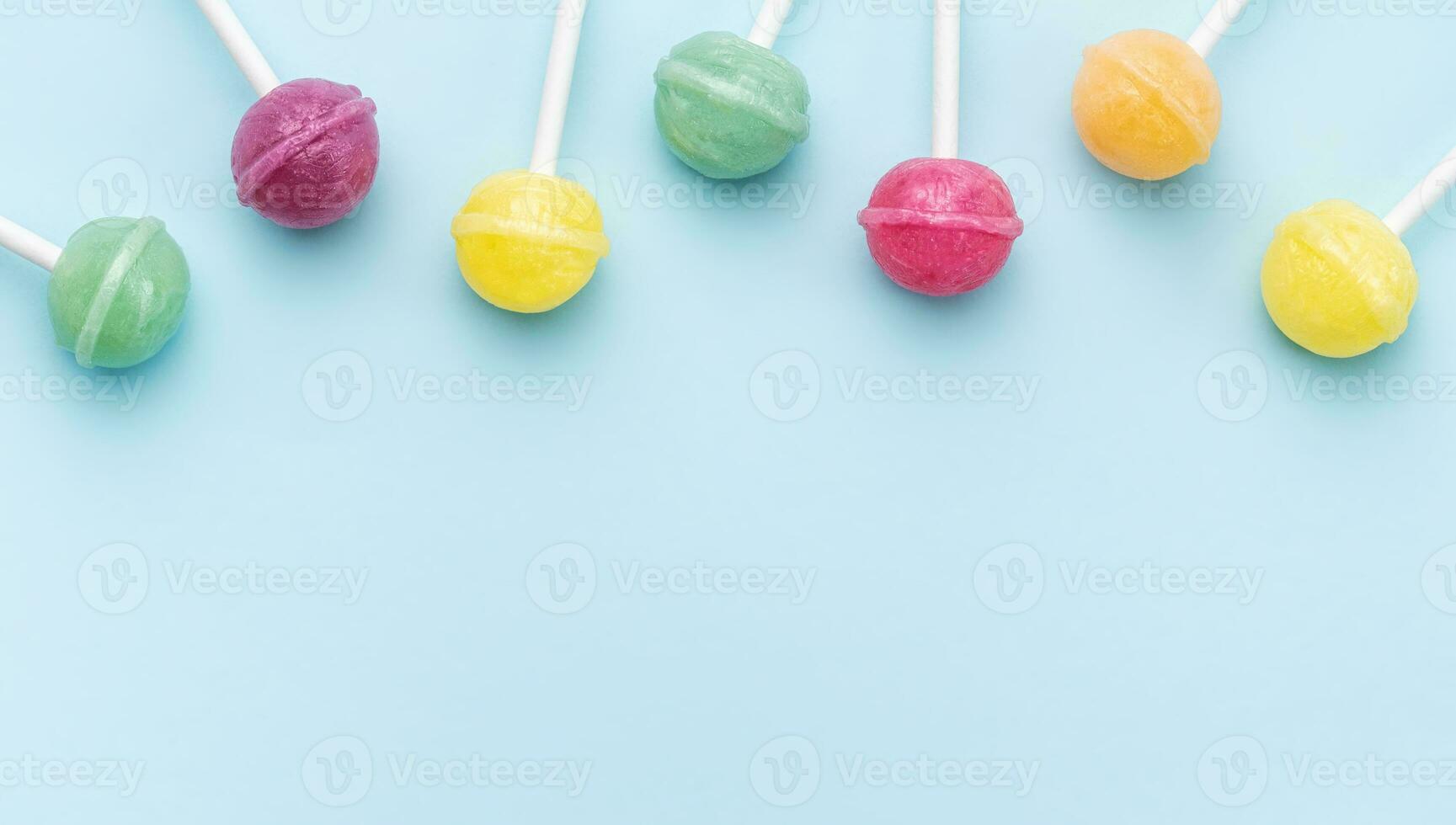 Sweet lollipops and candies on blue background photo