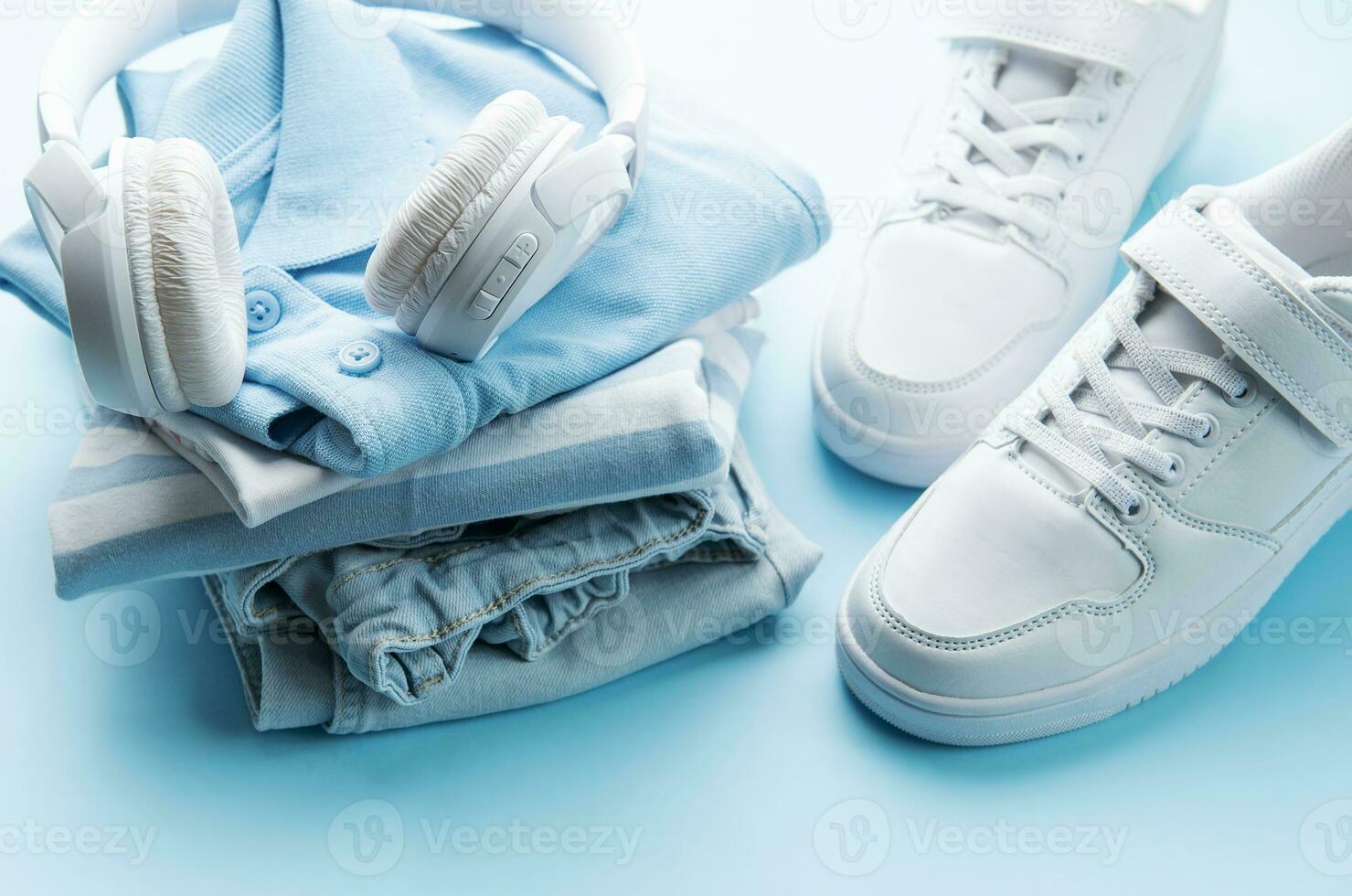 niño s t camisa, Zapatos y auriculares en azul fondo foto