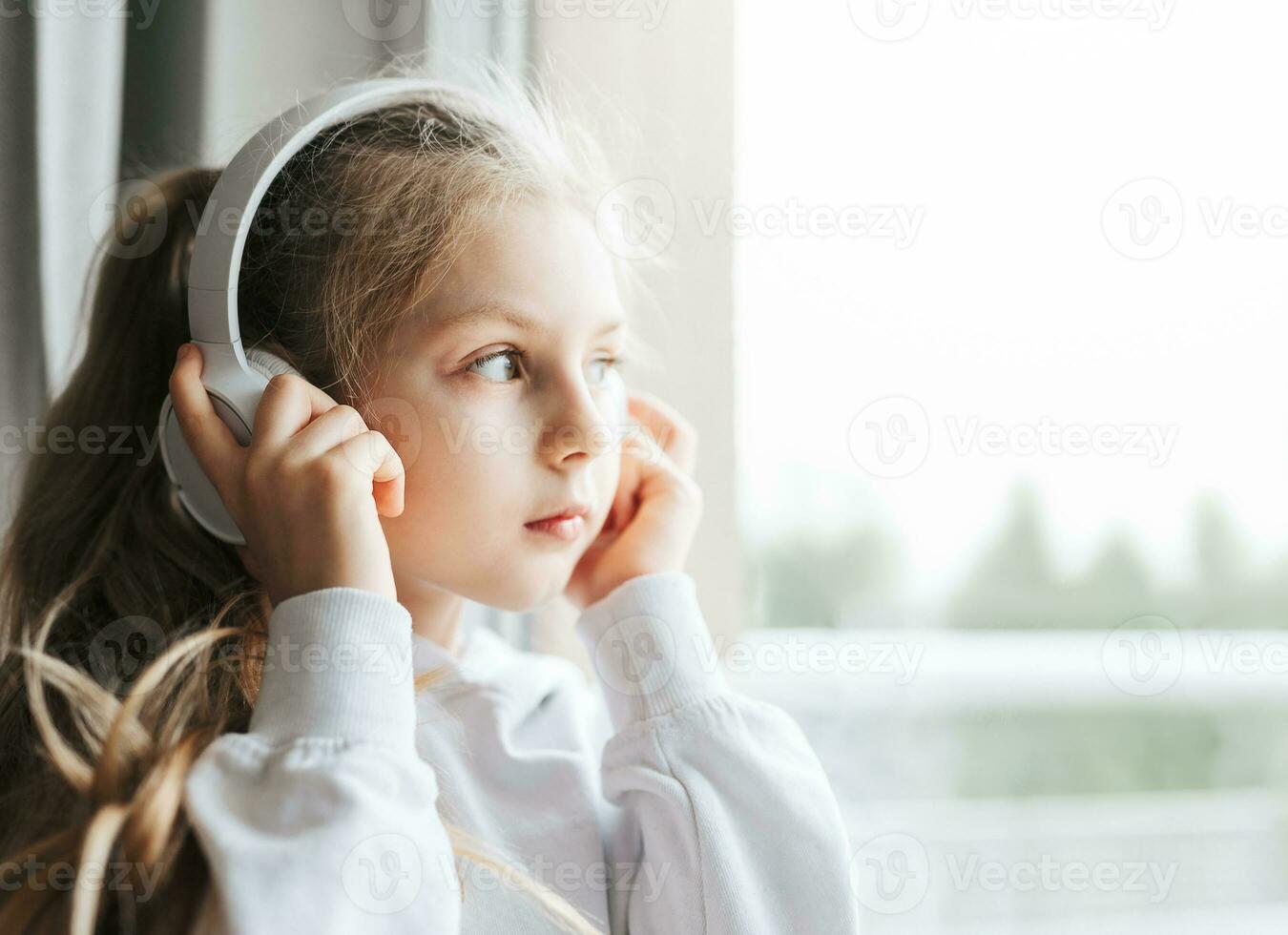 Little girl with headphones indoors at home photo