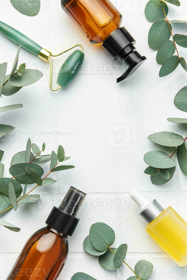 Spa treatment concept. natural spa cosmetics products with eucalyptus oil, massage jade roller, eucalyptus leaf. photo