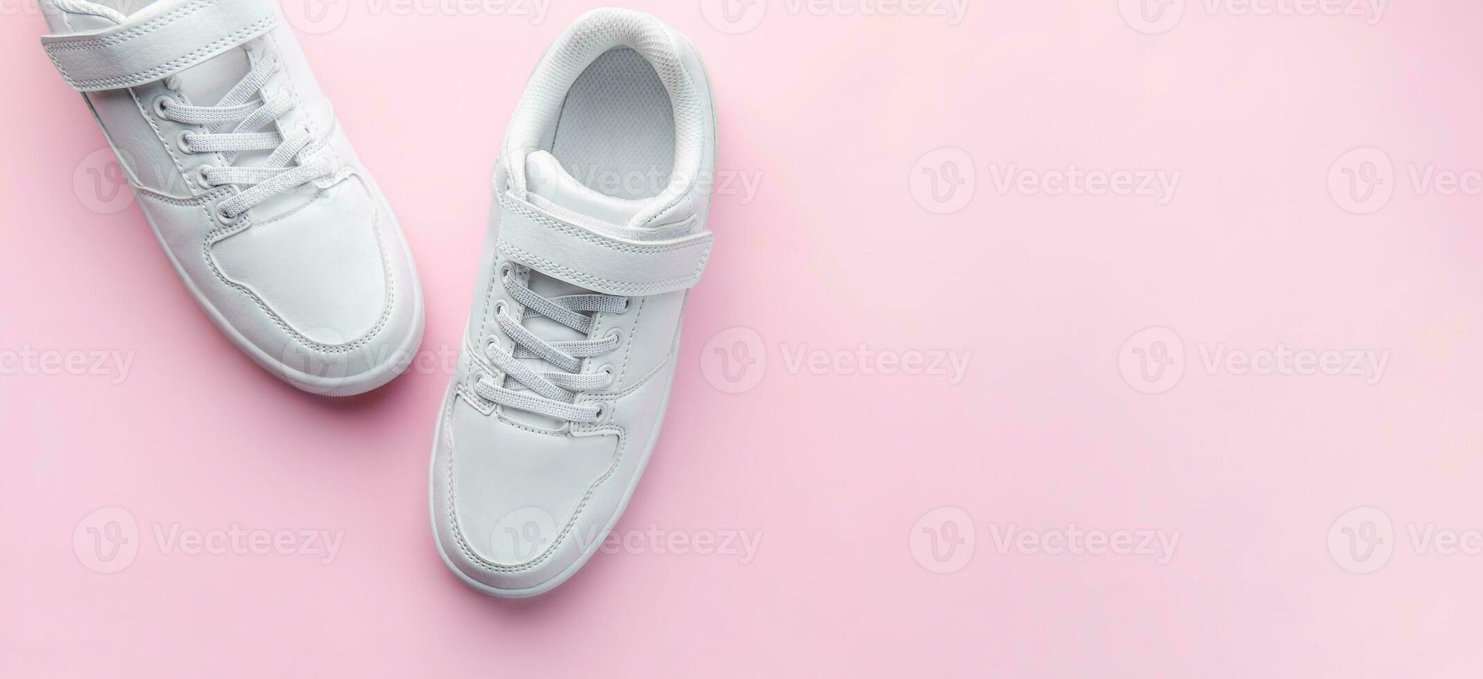 White sneakers on a pink background. photo