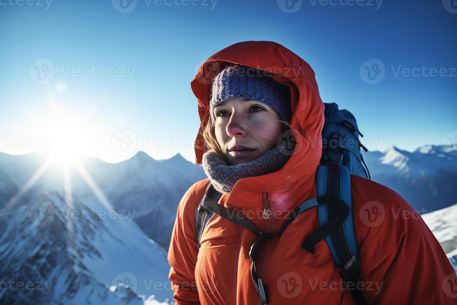 A mountaineer girl in a hoodie with a backpack in winter in the mountains wearing ski goggles. photo