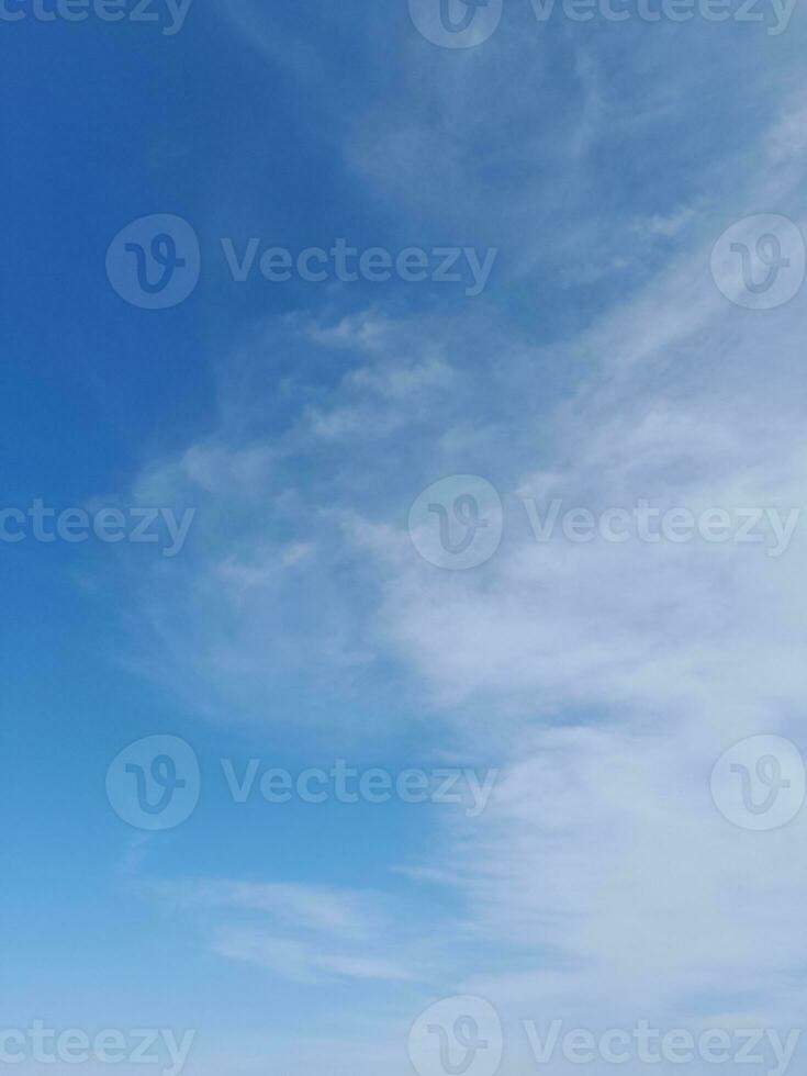 White clouds in the blue sky. Beautiful bright blue background. Light cloudy, good weather. Curly clouds on a sunny day. photo