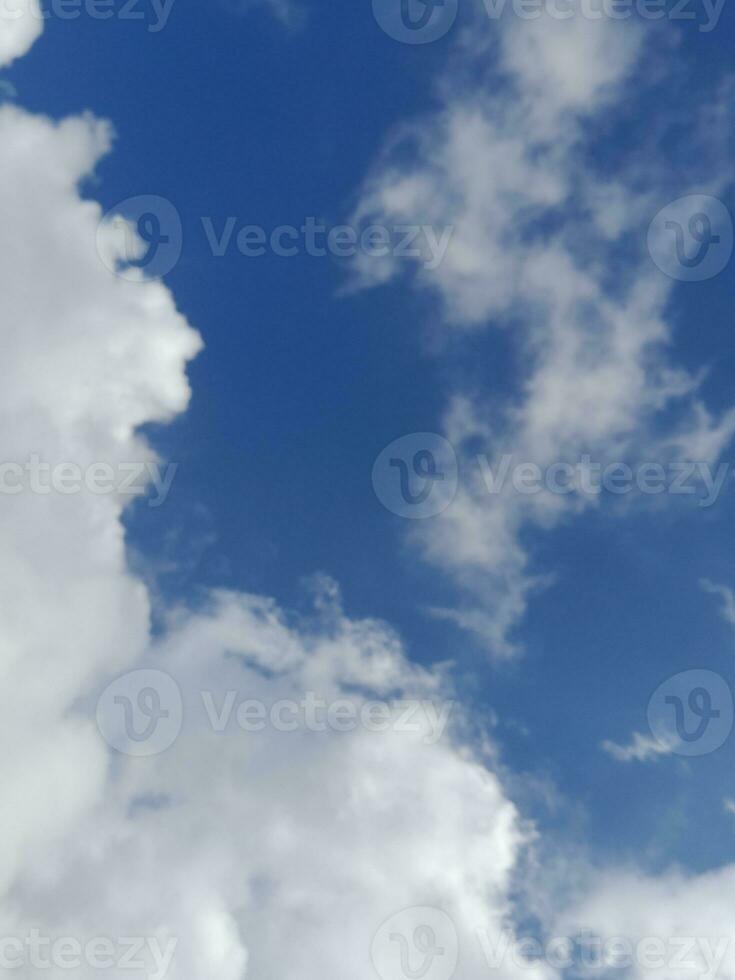 Beautiful white clouds on deep blue sky background. Large bright soft fluffy clouds are cover the entire blue sky. photo