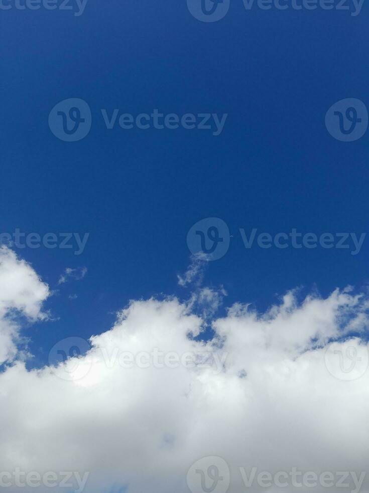 Beautiful white clouds on deep blue sky background. Large bright soft fluffy clouds are cover the entire blue sky. photo