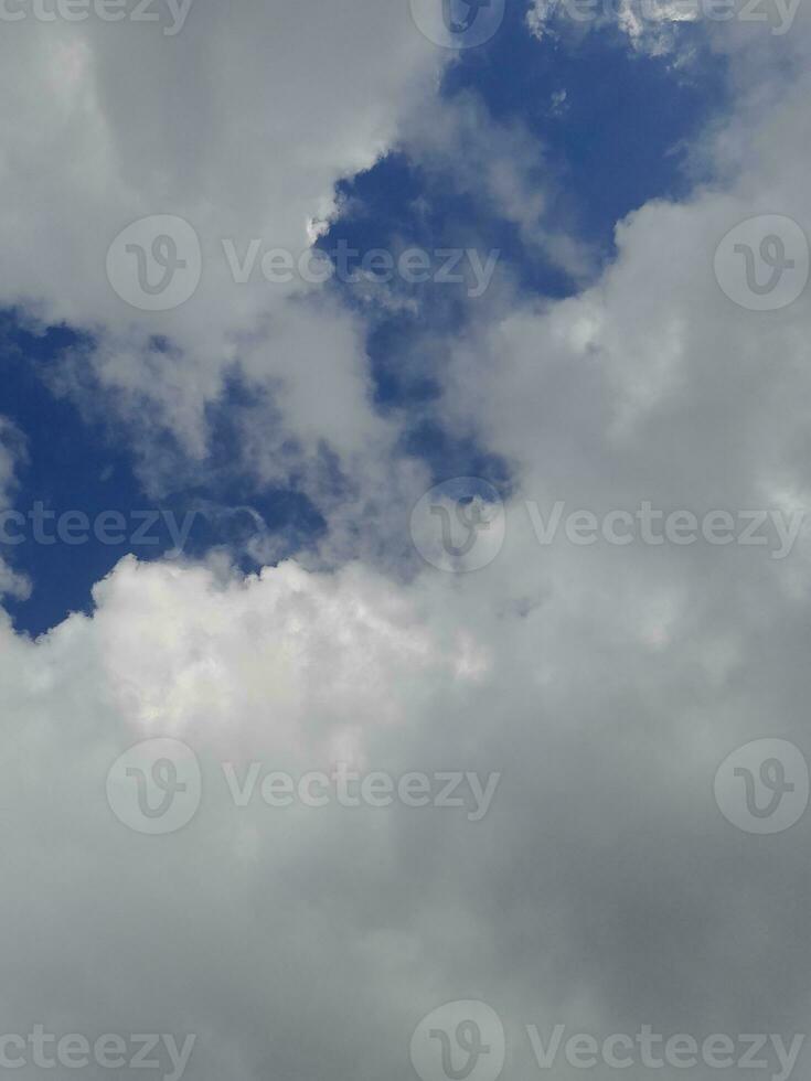 Beautiful white clouds on deep blue sky background. Large bright soft fluffy clouds are cover the entire blue sky. photo