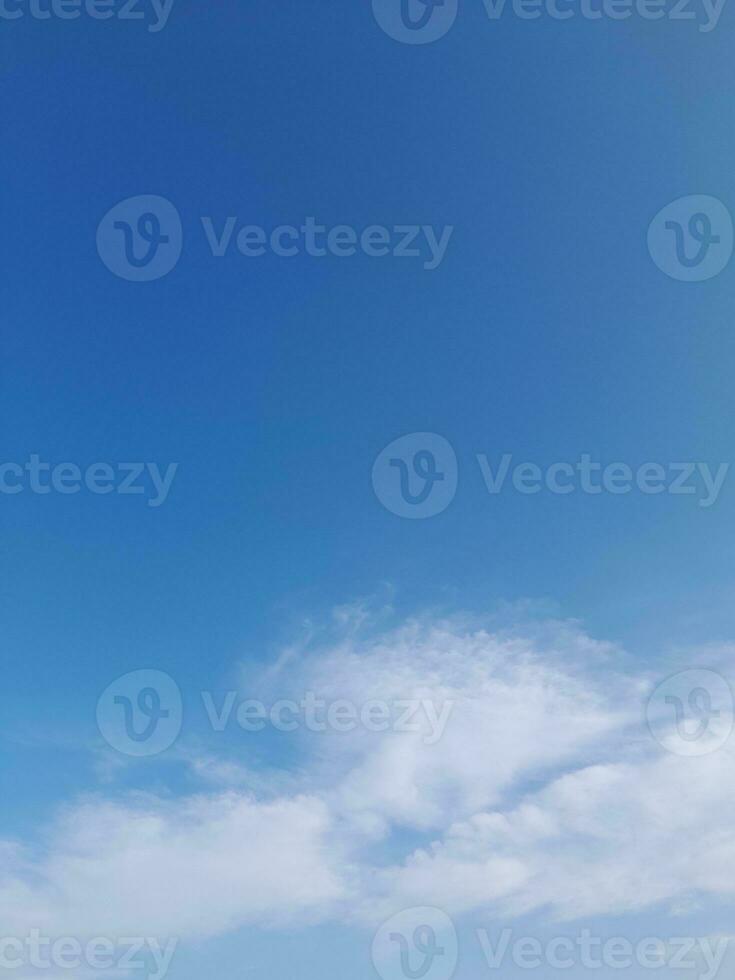 White clouds in the blue sky. Beautiful bright blue background. Light cloudy, good weather. Curly clouds on a sunny day. photo