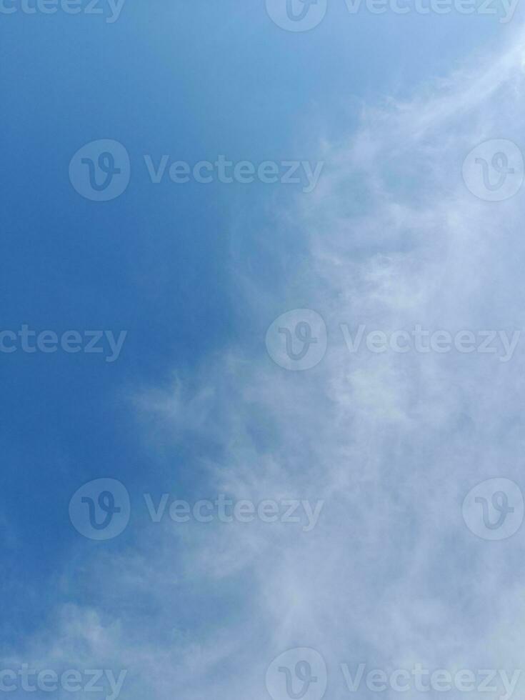 White clouds in the blue sky. Beautiful bright blue background. Light cloudy, good weather. Curly clouds on a sunny day. photo