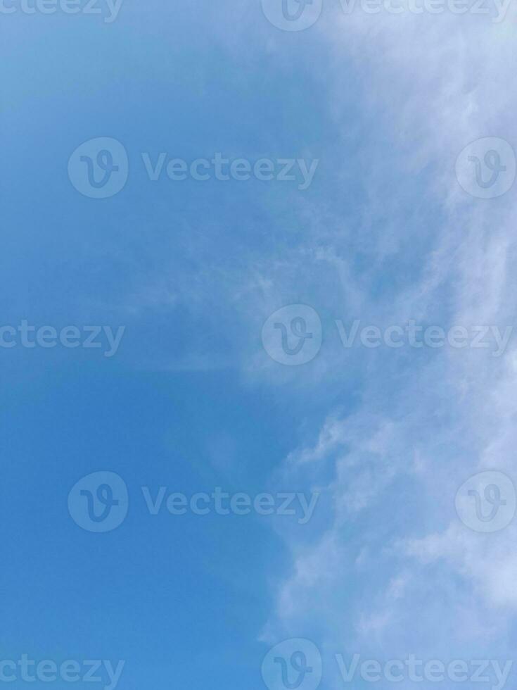 White clouds in the blue sky. Beautiful bright blue background. Light cloudy, good weather. Curly clouds on a sunny day. photo