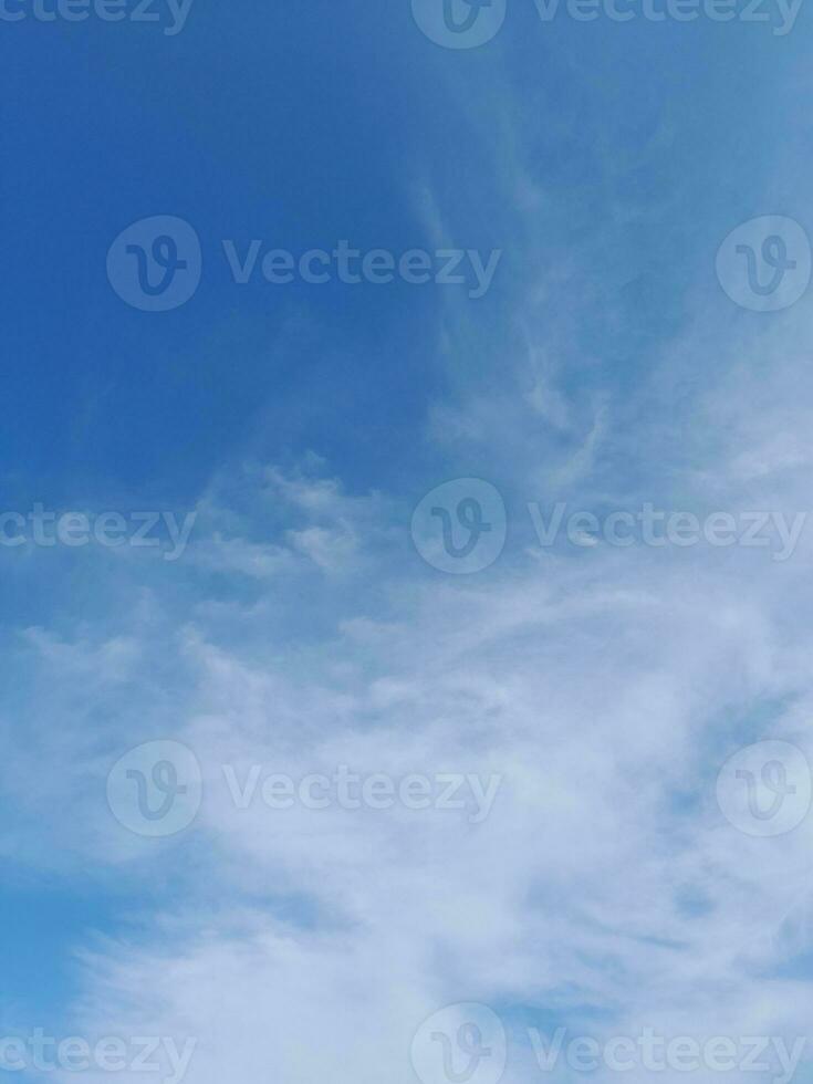 White clouds in the blue sky. Beautiful bright blue background. Light cloudy, good weather. Curly clouds on a sunny day. photo