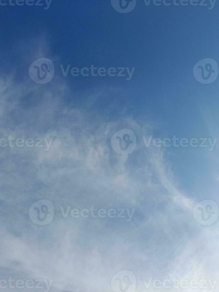 White clouds in the blue sky. Beautiful bright blue background. Light cloudy, good weather. Curly clouds on a sunny day. photo