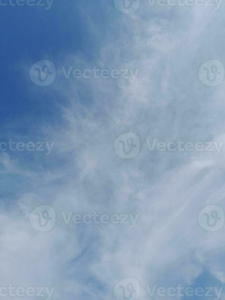 White clouds in the blue sky. Beautiful bright blue background. Light cloudy, good weather. Curly clouds on a sunny day. photo