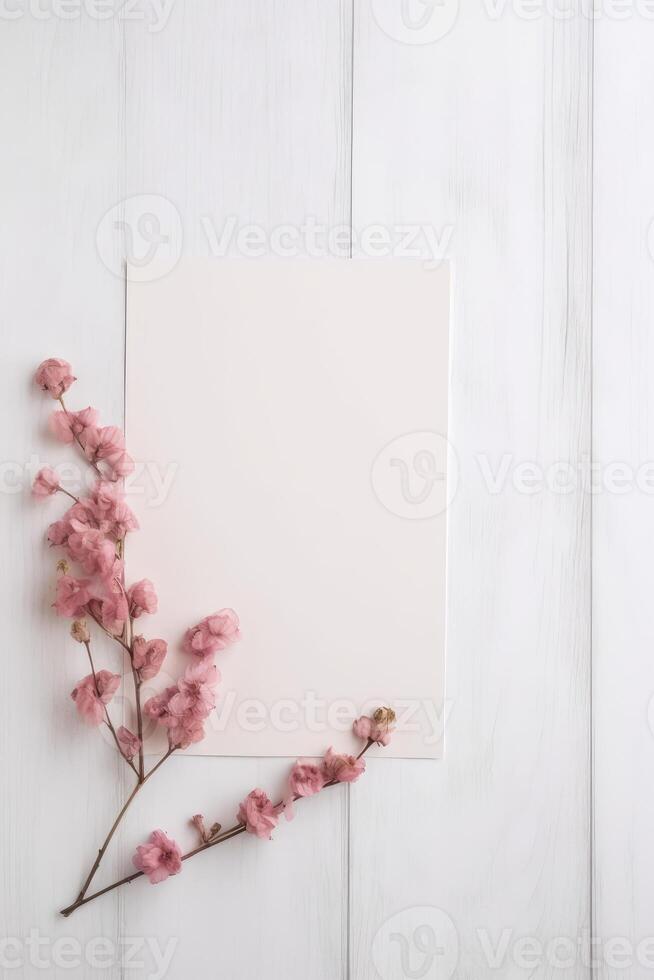 Blank Paper Card Mockup and Pink Cherry Flower Branch Flat Lay on White Wooden Table Top, . photo