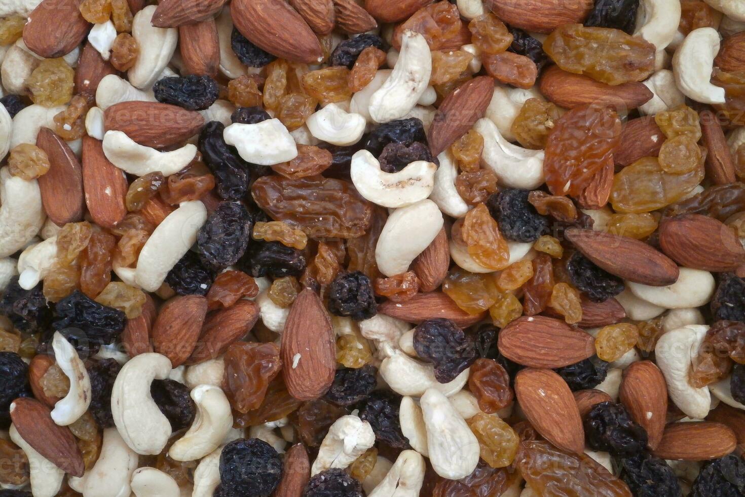 Stack of mixed nuts and dried raisins on a market stall photo