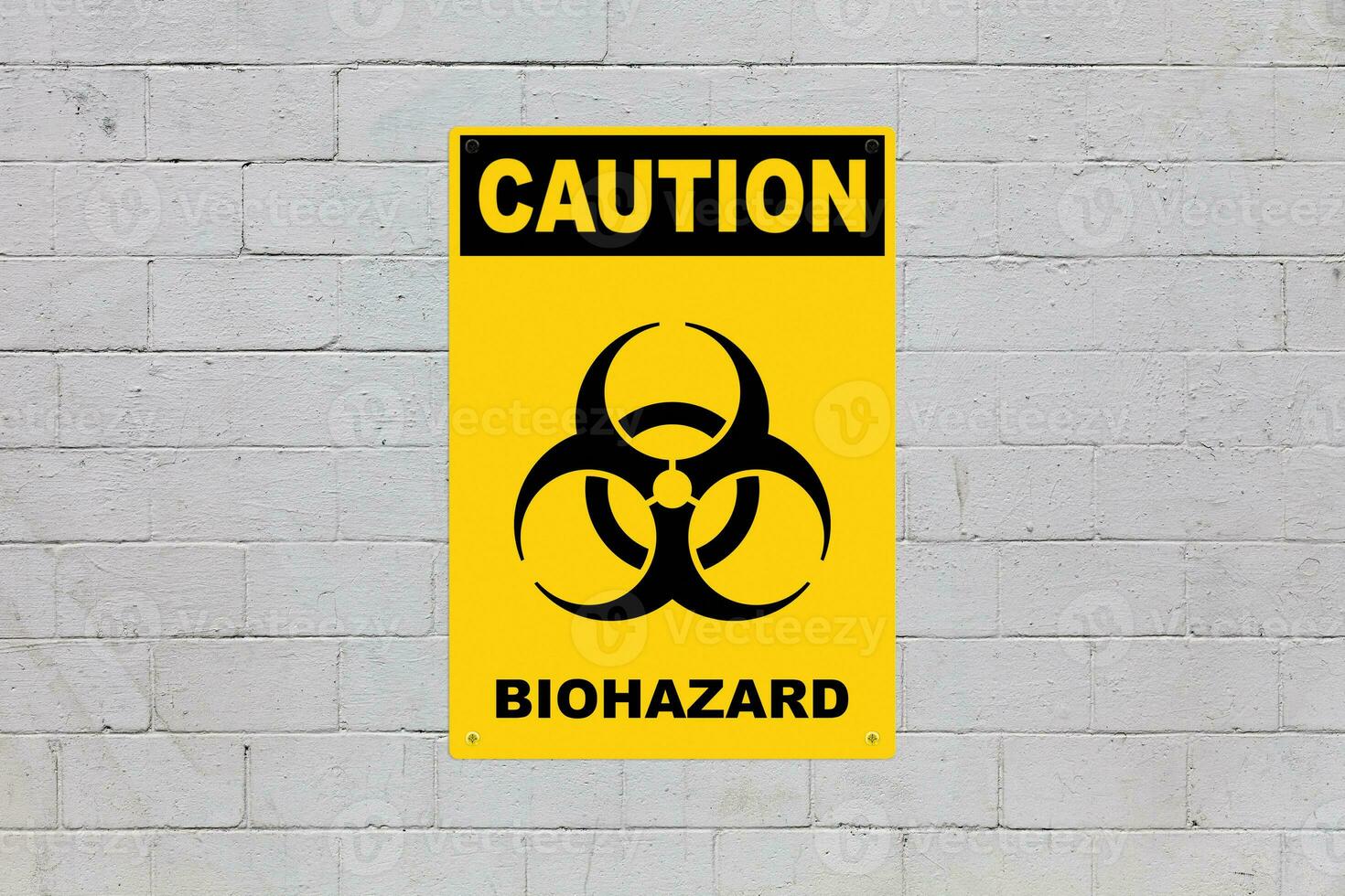 Caution, Biohazard sign on a cinder block wall photo