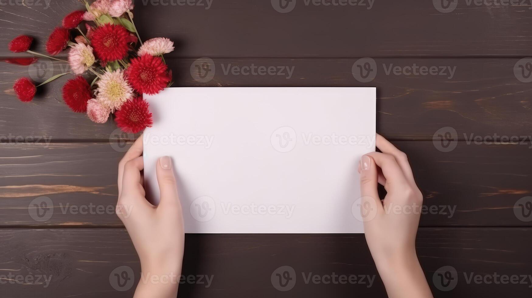 Top VIew Photo of Female Holding Blank White Paper Mockup and Beautiful Flowers on Wooden Table. .