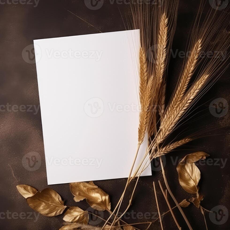 Top View of Blank White Paper with Golden Wheat, Leaves on Brown Texture Background and Placement. Vintage Delicate Business or Wedding Card Design. . photo
