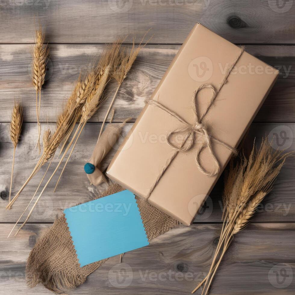 Top View of Rustic Style Packed Gift Box Tied with Burlap Thread, Blue Paper Sticky and Golden Dried Grain Grass on Wooden Table, . photo