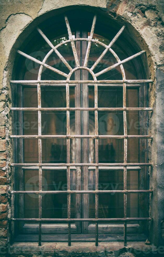 Ancient medieval window with wrought iron bars photo