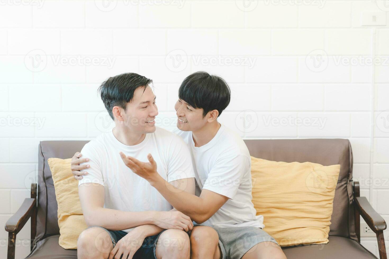 contento asiático gay Pareja abrazo juntos en sofá. asiático lgbt Pareja abrazando juntos a hogar. diversidad de lgbt relaciones un gay Pareja concepto. lgbt multi relación. foto