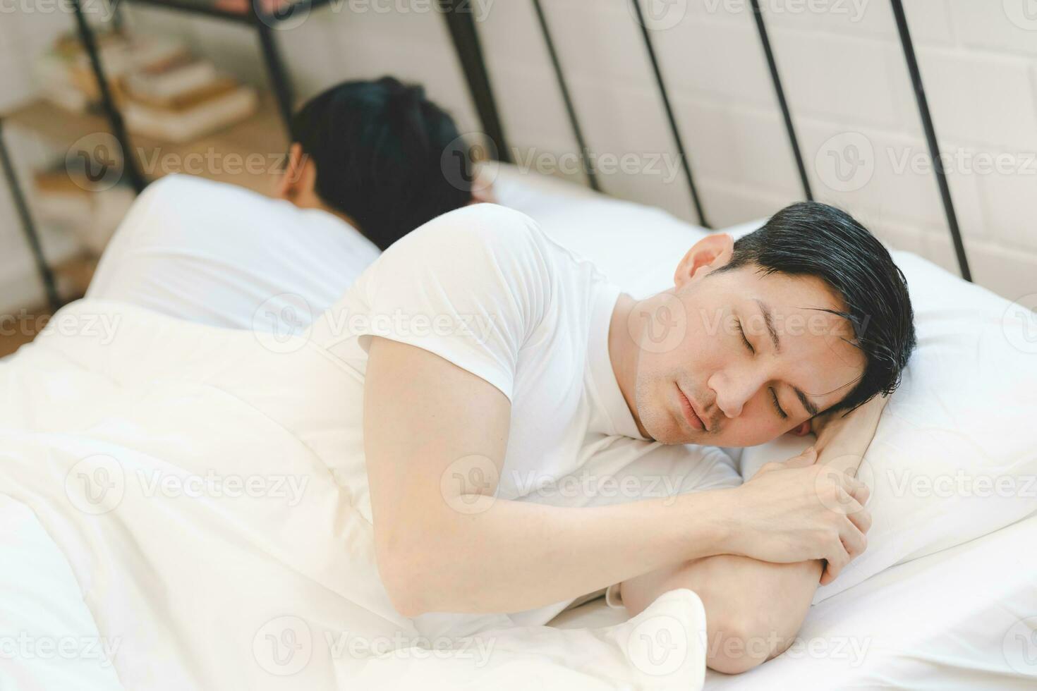 Asian gay couple feeling heartbroken for quarrel conflict and sleep in bedroom. Family problem separation. sad dissatisfied gay couple. Homosexual in problem relationship. photo